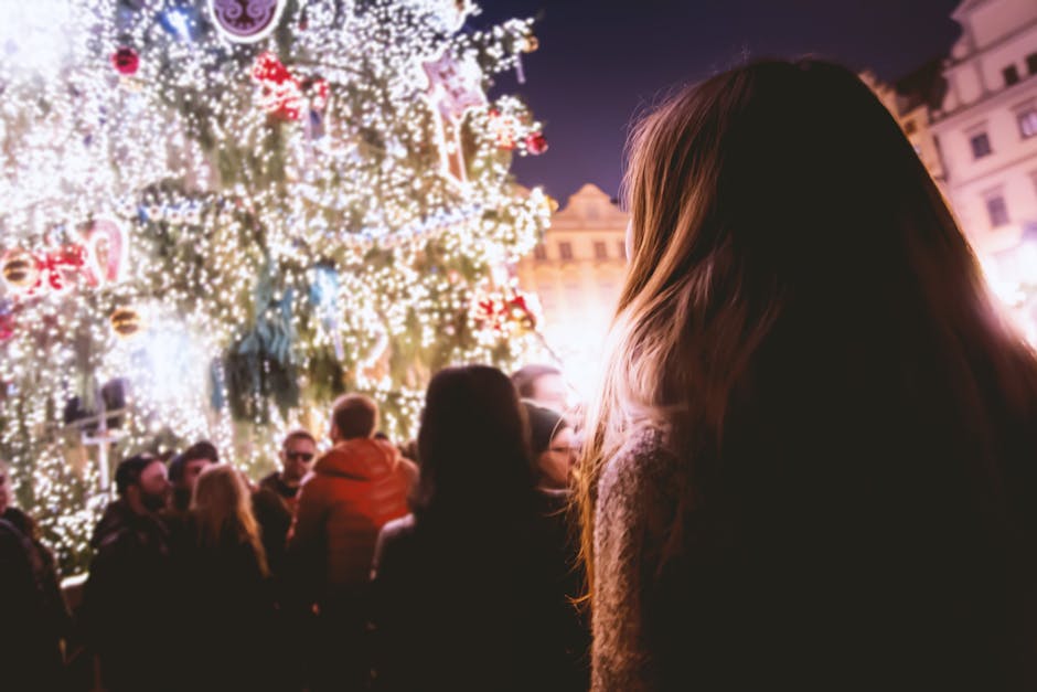 People enjoying a festive Christmas celebration with illuminated trees and joyful atmosphere at night.