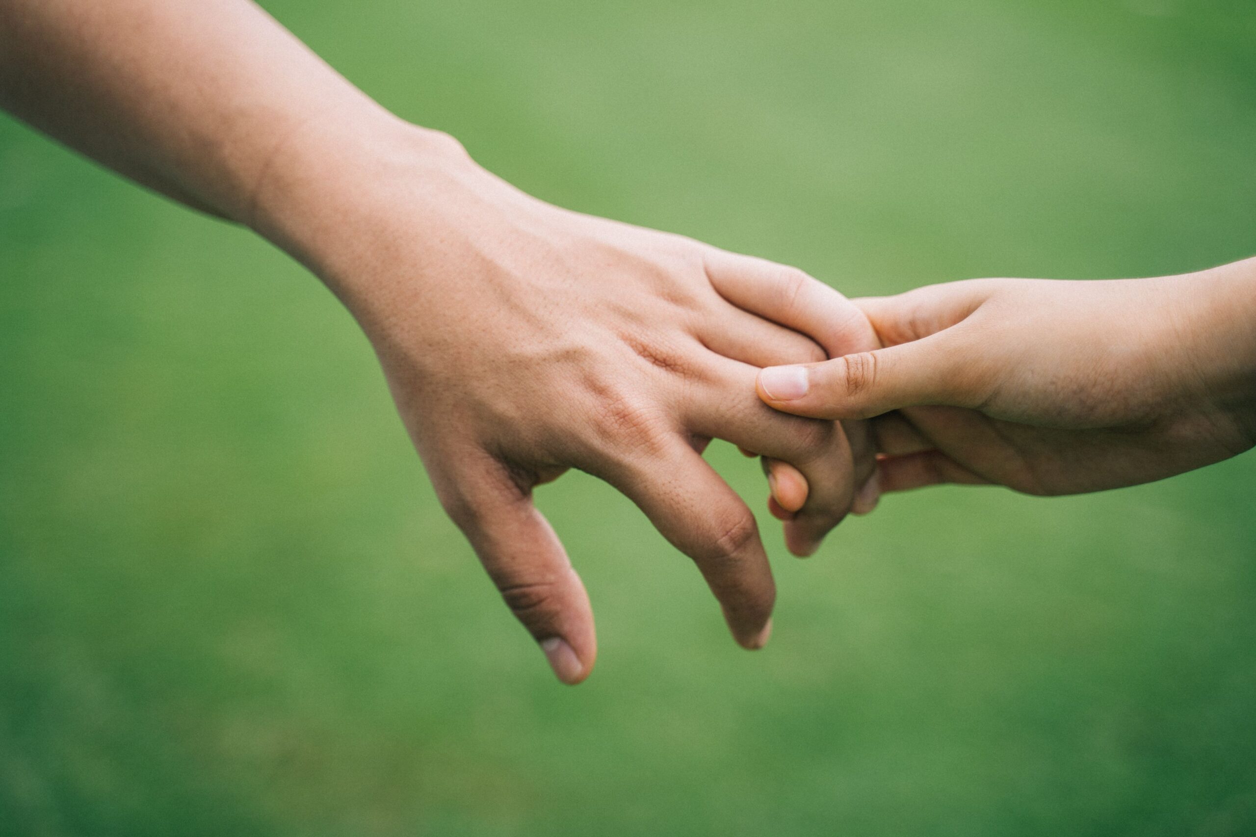 Two hands reaching out and gently touching, symbolizing connection and support.
